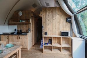 a kitchen and dining area of a tent with wooden walls at Big Oak in Hoogersmilde