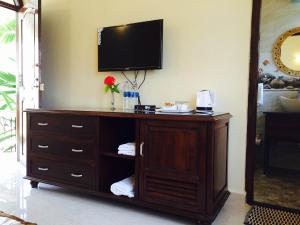 a wooden entertainment center with a television on a wall at Jacks Resort in Vagator