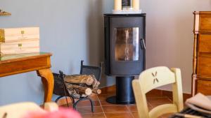 a wood burning stove in a room with chairs at Villa Poggio di Luna con piscina privata in Peschici