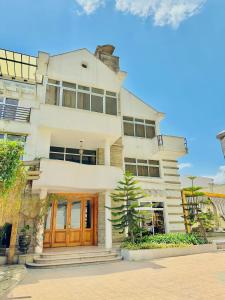 Un gran edificio blanco con puertas de madera marrones. en Social House, en Addis Ababa
