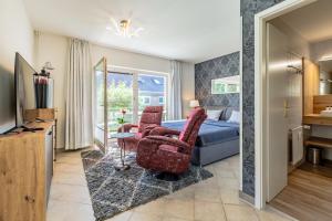 a hotel room with a bed and two chairs at Strandtraum Lobbe Fewo 6, auf Anfrage mit Strandkorb in Lobbe