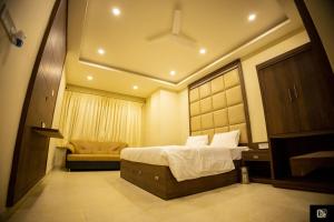 a bedroom with a bed and a chair in it at King's Crown Hotel in Garifa