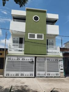 a green and white building with a window at Casa para vacaciones Neiva Rivera Huila in Rivera