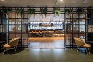 a room with a table and chairs and plants at Scandic Simonkenttä in Helsinki