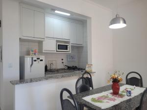 a kitchen with white cabinets and a table with chairs at Rê apdetemporadas em Olímpia 53 o melhor para sua Família Faça ja sua reserva in Olímpia