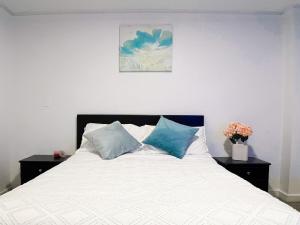 a bedroom with a white bed with blue pillows at Sky Loft 3 cuadras a la UTPL 5min del centro in Loja