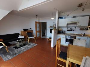 eine Küche und ein Wohnzimmer mit einer Couch und einem Tisch in der Unterkunft Sünnenkringel in Zingst