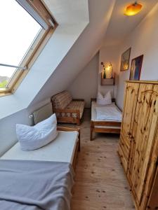 ein Schlafzimmer im Dachgeschoss mit zwei Betten und einem Fenster in der Unterkunft Sünnenkringel in Zingst