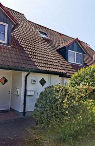 ein weißes Haus mit einem Dach und einem Fenster in der Unterkunft Sünnenkringel in Zingst