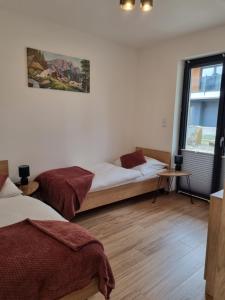 ein Schlafzimmer mit zwei Betten und einem Fenster in der Unterkunft Szczyrkowska Ostoja in Szczyrk