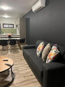 a living room with a black couch and a table at Casa do Dylan in Khomas Region