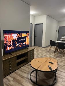 a living room with a flat screen tv and a table at Casa do Dylan in Khomas Region