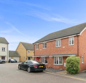 a black car parked in front of a brick house at 3 Bed - Sleeps 7 - Hot-Tub - Free Parking in Hornchurch