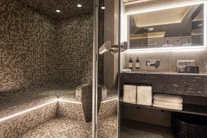 une salle de bain avec une douche avec une porte vitrée dans l'établissement B Montmartre, à Paris 86 autres photos