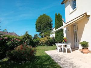 patio ze stołem i krzesłami na podwórku w obiekcie Maison de charme proche centre ville w mieście Avranches +7 zdjęć