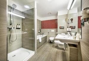 W łazience znajduje się prysznic, umywalka i toaleta. w obiekcie Wellness Hotel Diamant w mieście Hluboká nad Vltavou