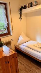 a small bedroom with a bed and a window at Waldtwin 2 Titisee (W12) + Hochschwarzwald Card in Titisee-Neustadt