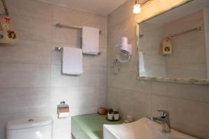 a bathroom with a sink and a mirror and a toilet at Meltemi Hotel Kythnos-Loutra in Loutra +75 photos