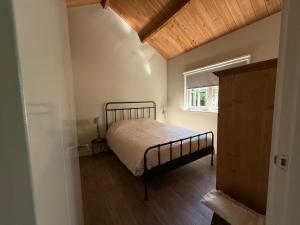 a bedroom with a bed and a window at Het plekje dat niemand wist in Ederveen