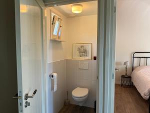 a small bathroom with a toilet and a bed at Het plekje dat niemand wist in Ederveen
