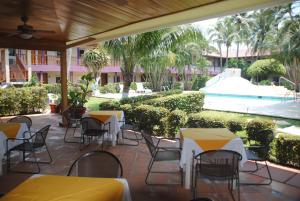 a patio with tables and chairs and a pool at Los Andes Coatzacoalcos in Coatzacoalcos