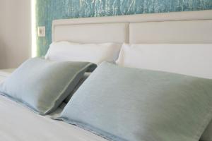 a bed with two pillows sitting next to a window at Catania Over Time - Tourist Rooms in Catania
