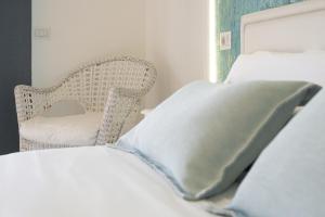 a bed with a pillow and a chair in a room at Catania Over Time - Tourist Rooms in Catania
