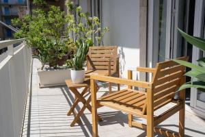 two wooden chairs sitting on a porch with plants at Catania Over Time - Tourist Rooms in Catania