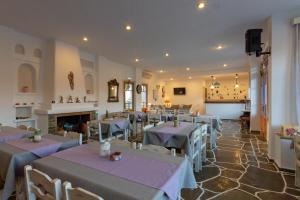 a restaurant with tables and chairs and a fireplace at Meltemi Hotel Kythnos-Loutra in Loutra