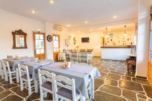 a dining room with two tables and a kitchen at Meltemi Hotel Kythnos-Loutra in Loutra