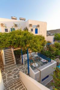 a staircase leading up to a building with tables and chairs at Meltemi Hotel Kythnos-Loutra in Loutra