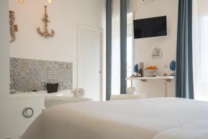 a bedroom with a white bed and a tub at Catania Over Time - Tourist Rooms in Catania