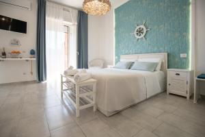 a bedroom with a white bed and a blue wall at Catania Over Time - Tourist Rooms in Catania