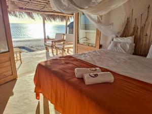 a bedroom with a bed with two towels on it at Beheloka Lodge in Ambalaviro