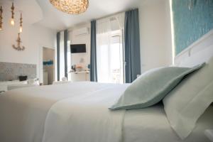 a bedroom with a white bed with a green pillow at Catania Over Time - Tourist Rooms in Catania