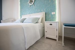 a bedroom with a white bed and a blue wall at Catania Over Time - Tourist Rooms in Catania