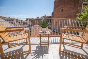 two chairs and a plant on a balcony at Catania Over Time - Tourist Rooms in Catania