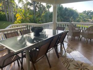 a glass table and chairs on a porch at Villa Belles Vacances in Sosúa