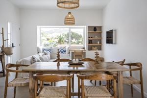 ein Esszimmer mit einem Holztisch und Stühlen in der Unterkunft Casa do Cacto - By WeHost in Porto Santo