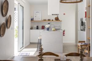 eine Küche mit weißen Schränken und einer Arbeitsplatte in der Unterkunft Casa do Cacto - By WeHost in Porto Santo