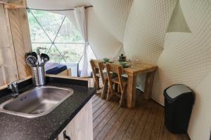 a kitchen with a sink and a table in a tent at Dome XXL in Hoogersmilde