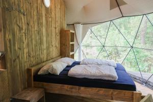 a bed in a room with a large window at Dome XXL in Hoogersmilde