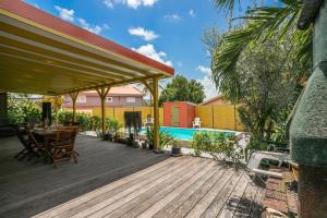 圣吕斯Villa H'Om Zen的一个带桌椅的甲板和一个游泳池