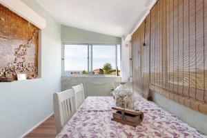a dining room with a table and a window at Bisa's house in Estoril