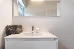 a bathroom with a white sink and a mirror at Bisa's house in Estoril