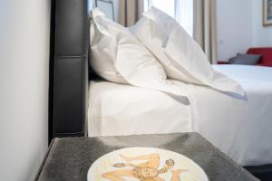 a table with a plate on it next to a bed at Catania Over Time - Tourist Rooms in Catania