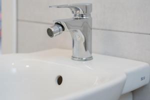 a bathroom sink with a faucet on top of it at Catania Over Time - Tourist Rooms in Catania