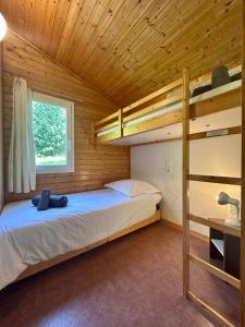 una camera con letti a castello in una cabina di legno di Chalet de 4 pers - Lac de Miel à 500m - Beynat - Parking Piscine a Beynat