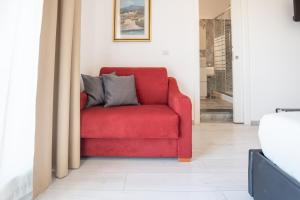 a red chair sitting in a living room at Catania Over Time - Tourist Rooms in Catania