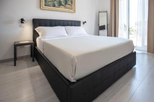 a bed with a black frame in a bedroom at Catania Over Time - Tourist Rooms in Catania